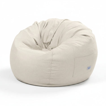 Cream fabric bean bag with curved top seam and side pocket panel, includes small tag