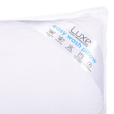 White pillow with blue 'easy wash pillow' label at corner