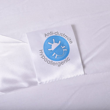 Anti-dustmite and hypoallergenic label on white bolster pillow cover.