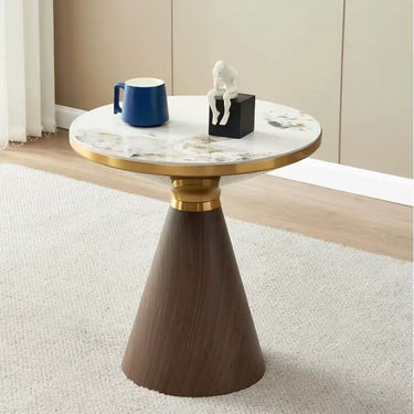 Round side table with white marble-look top, gold pedestal base, dark tapered legs