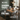 Promotional dining room scene with a wooden dining table and upholstered chairs in a real interior setting, overlaid with sale text reading 'BLIMS DINING SALE' and 'Save up to P10,000'.