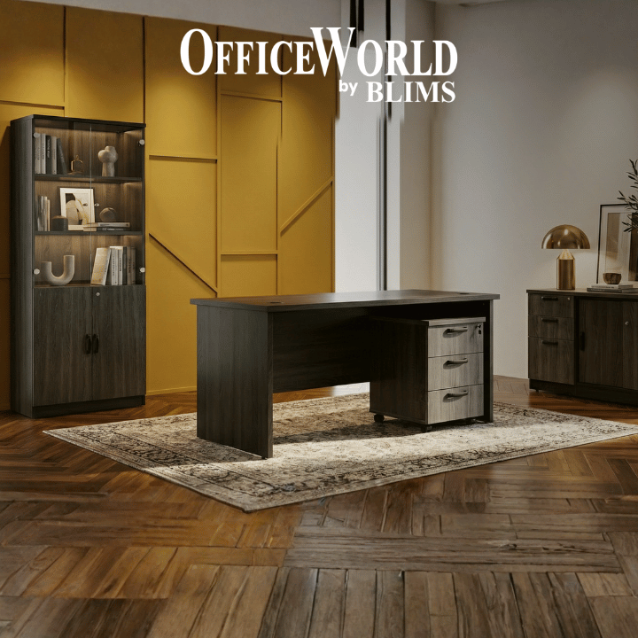Modern office setup with a desk and bookshelf in a room with wooden flooring and yellow walls.