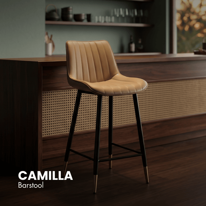 CAMILLA barstool with tan cushioned seat, curved back, and black metal legs with footrest