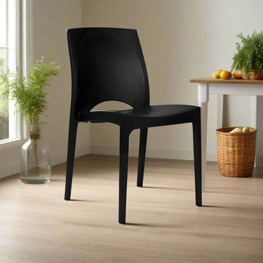 Black molded plastic chair with arched back and cutout seat, side view, four legs