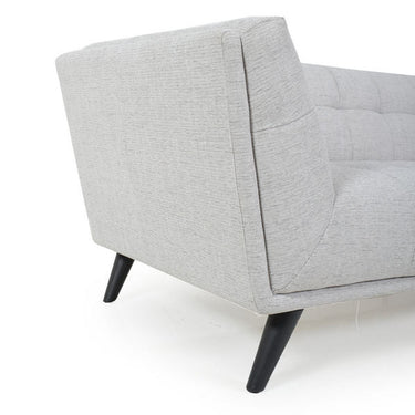 Light gray 3-seater sofa side view with tufted back panel and black tapered legs